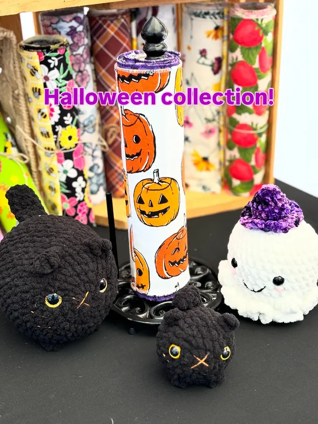 Halloween collection: two crochet black cats, a white crochet ghost in a purple witch hat, and a jack-o-lantern paperless towel roll.